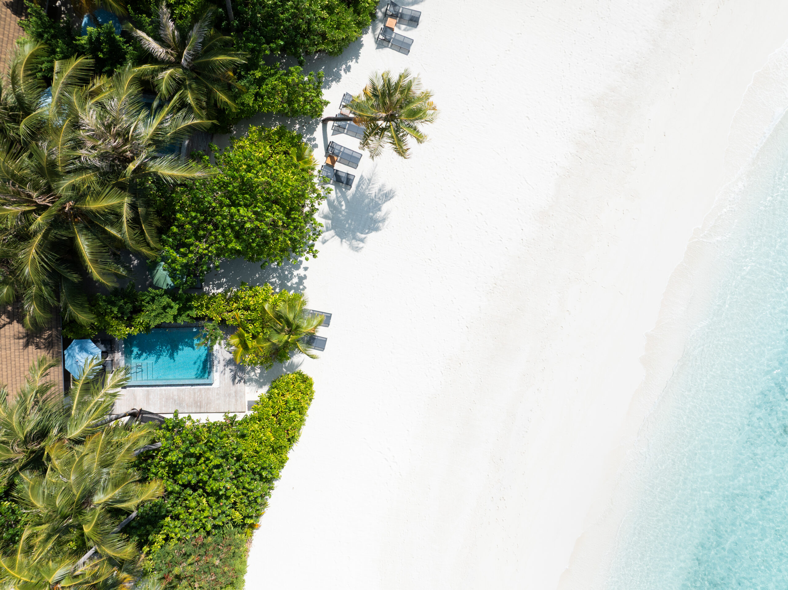 Aerial view of Beach Villa with pool, white sandy beach in front of the villa with turquoise sea.